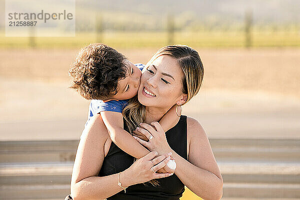 Little boy kissing his mom on the cheek