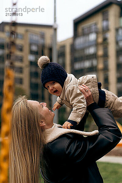 Mom kissing little son in the park