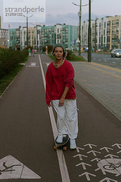 A young woman rides a skateboard along the city streets