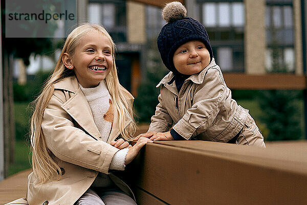 Sister plays with her younger little brother in the park