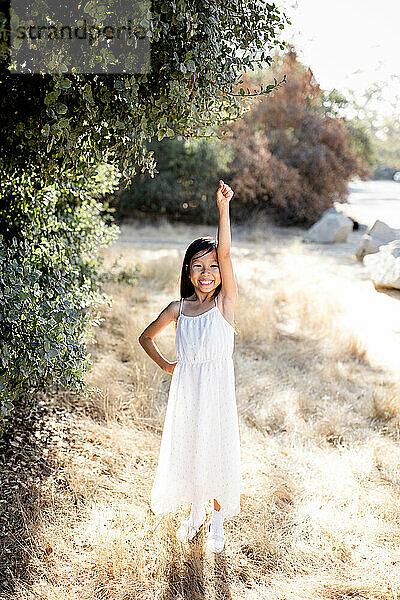 Seven Year Old Girl Standing with Arm in Air on Sunny Day in San Diego