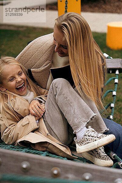 Mom and daughter hugging on a hammock in the park  close-up portrait