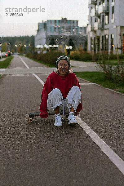 A young woman rides a skateboard along the city streets