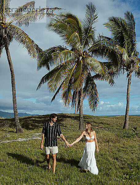 Couple holding hands walking looking at eachother