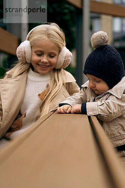 Sister plays with her younger little brother in the park