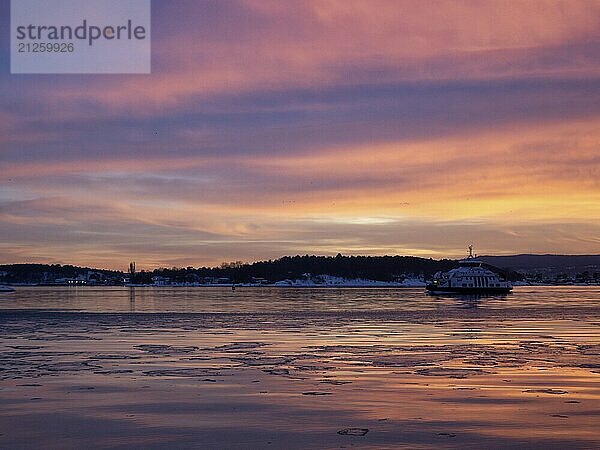 Ein schöner Sonnenuntergang über dem Oslofjord mit einer Fähre im Anflug auf Oslo