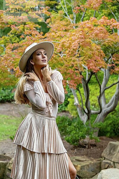 Ein umwerfendes Model präsentiert Herbstmode inmitten der Schönheit der Natur und verströmt Eleganz und Charme in einem malerischen Park