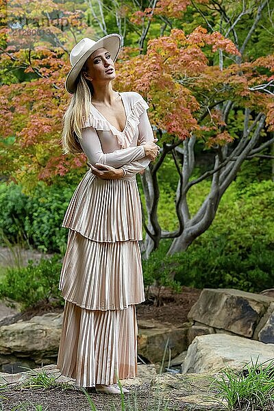 Ein umwerfendes Model präsentiert Herbstmode inmitten der Schönheit der Natur und verströmt Eleganz und Charme in einem malerischen Park