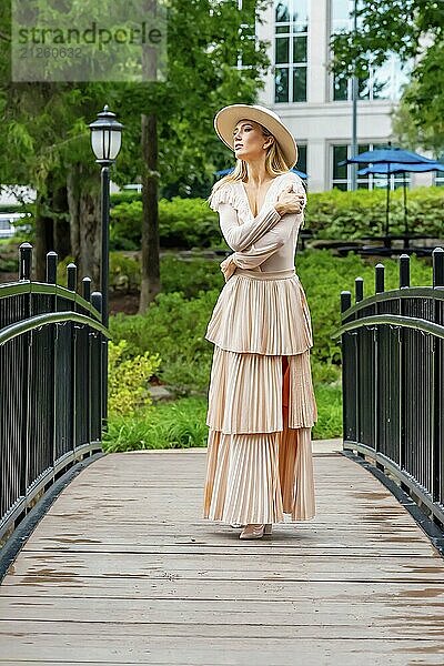 Ein umwerfendes Model präsentiert Herbstmode inmitten der Schönheit der Natur und verströmt Eleganz und Charme in einem malerischen Park