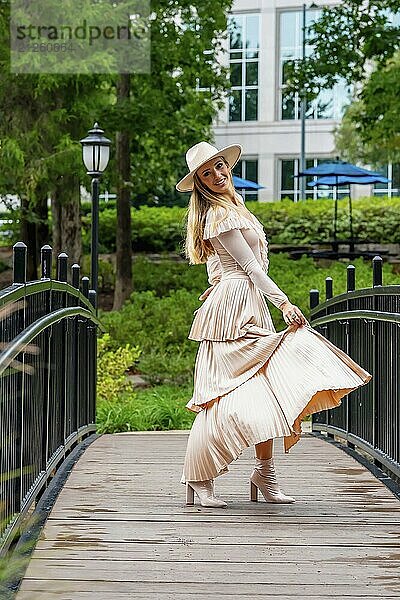 Ein umwerfendes Model präsentiert Herbstmode inmitten der Schönheit der Natur und verströmt Eleganz und Charme in einem malerischen Park