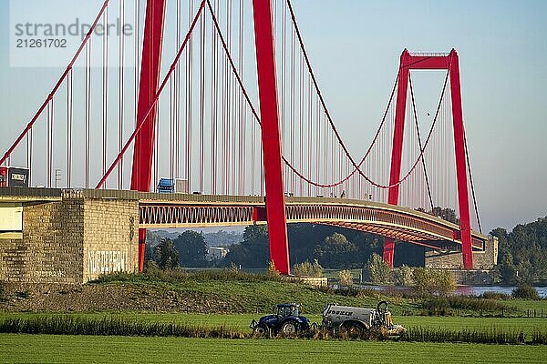 Die Rheinbrücke Emmerich  Bundesstraße B220  längste Hängebrücke Deutschlands  wird zur Zeit saniert  Brückenschäden  Landwirt mit Trecker bringt Gülle auf das Feld  Niederrhein  Nordrhein-Westfalen  Deutschland  Europa