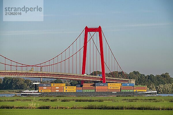 Die Rheinbrücke Emmerich  Bundesstraße B220  längste Hängebrücke Deutschlands  wird zur Zeit saniert  Brückenschäden  Containerfrachtschiff auf dem Rhein  Niederrhein  Nordrhein-Westfalen  Deutschland  Europa