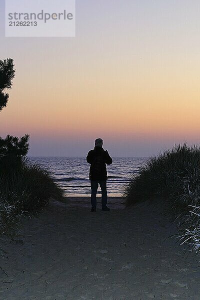 Sonnenaufgang am Ostseestrand bei Karlshagen  Mann mit Kamera  September  Usedom  Mecklenburg-Vorpommern  Deutschland  Europa