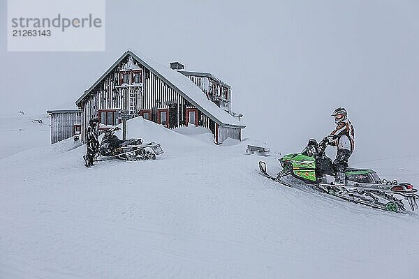 Mann fährt auf Schneemobil  Skidoo  Berghütte  Schnee  Laktatjakko  Björkliden  Laponia  Lappland  Schweden  Europa