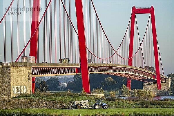 Die Rheinbrücke Emmerich  Bundesstraße B220  längste Hängebrücke Deutschlands  wird zur Zeit saniert  Brückenschäden  Landwirt mit Trecker bringt Gülle auf das Feld  Niederrhein  Nordrhein-Westfalen  Deutschland  Europa