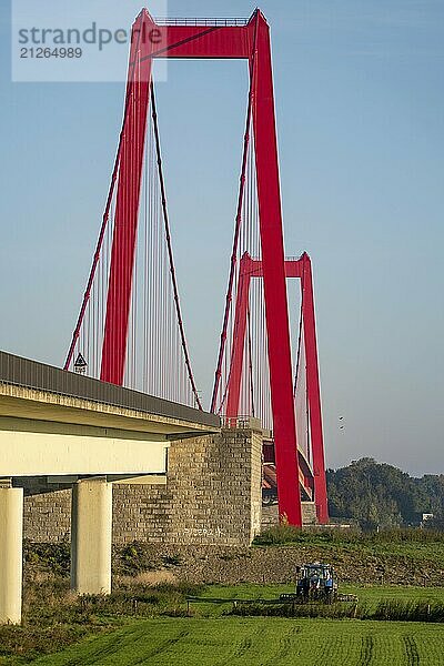 Die Rheinbrücke Emmerich  Bundesstraße B220  längste Hängebrücke Deutschlands  wird zur Zeit saniert  Brückenschäden  Landwirt mit Trecker bringt Gülle auf das Feld  Niederrhein  Nordrhein-Westfalen  Deutschland  Europa