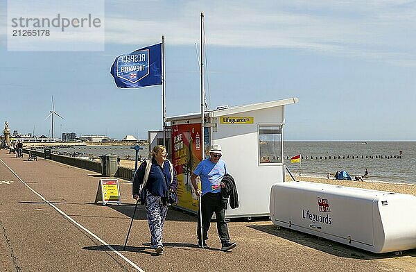 Menschen  die mit Stöcken an der Rettungsschwimmerstation an der Esplanade vorbeigehen  Lowestoft  Suffolk  England  UK