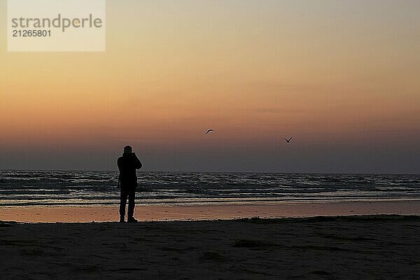 Sonnenaufgang am Ostseestrand bei Karlshagen  Mann mit Kamera  September  Usedom  Mecklenburg-Vorpommern  Deutschland  Europa