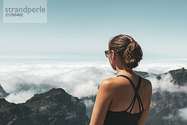 Frau blickt von einem Berggipfel über eine Wolkendecke  friedliche Atmosphäre  Pico Ruivo  Madeira  Portugal  Europa