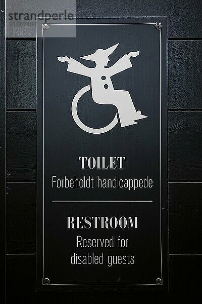 Schild für behindertengerechte Toilette mit Rollstuhlsymbol auf schwarzem Hintergrund  Vergnügungs- und Erholungspark Tivoli  Kopenhagen  Dänemark  Europa