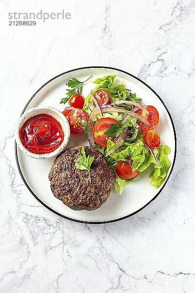 Lebensmittel  Rindfleisch Hamburger mit Salat Tomaten Salat auf weißem Teller  Ansicht von oben