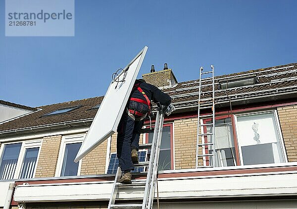 Mann klettert über die Leiter auf das Dach mit Solarpanel