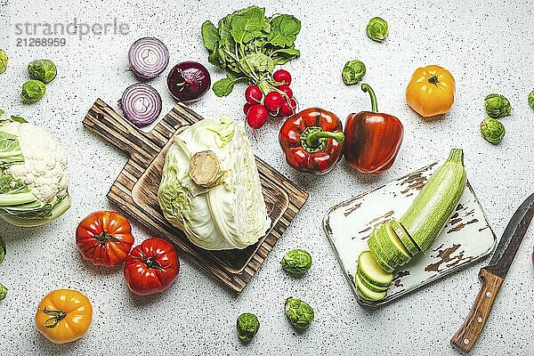 Frische verschiedene Gemüse mit hölzernen Schneidebretter und Messer auf weißen Küchentisch Draufsicht. Kochen vegetarische Mahlzeit aus gesunden Zutaten  Diät Lebensmittel und Ernährung Konzept  Lebensmittel Fotografie  food photography  food photography