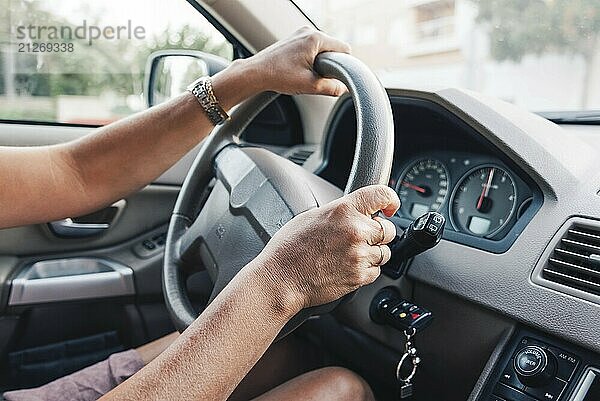 Nahaufnahme einer Frau  die mit den Händen ein Auto fährt. Fokus auf die Hand