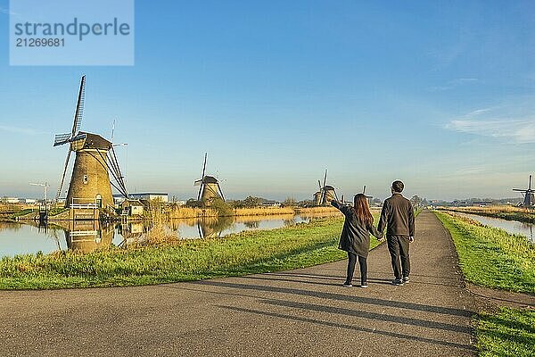 Niederländische Windmühlenlandschaft in Kinderdijk Dorf Niederlande mit Liebespaar zu Fuß