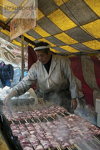 24.12.2017  Kyoto  Japan  Asien  Ein Mann bereitet frisch gebratene Yakitori Rindfleischspieße an einem Stand im Park des Fushimi Inari Taisha Sanshuden vor  Asien