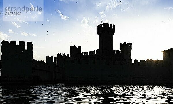 Italien  Sirmone Burg Silhouette auf dem Gardasee bei Sonnenuntergang. Mittelalterliche Architektur mit Turm  Europa