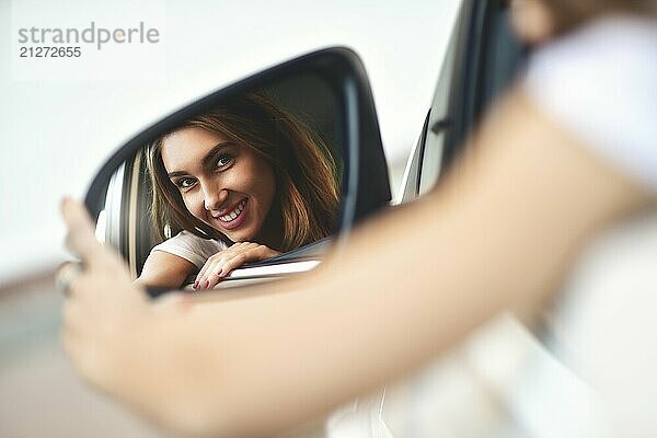 Porträt von niedlichen lächelnden Mädchen sitzen in der .car und Blick auf das Auto Spiegel