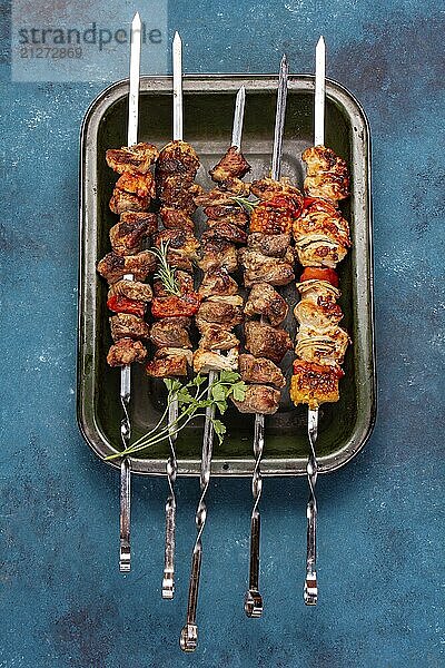 Food  Food  Lebensmittel  Bbq gegrilltes Fleisch Schweinefleisch  Huhn und Gemüsespieße auf Tablett. Ansicht von oben  flach gelegt. Blauer Hintergrund