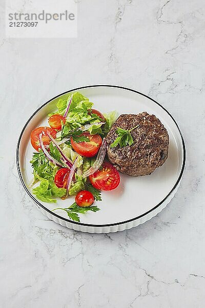 Lebensmittel  Rindfleisch Hamburger mit Salat Tomaten Salat auf weißem Teller  Ansicht von oben