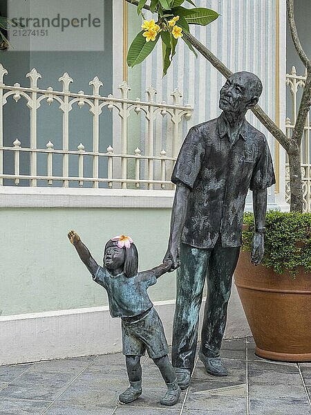 Bronzeskulptur von Chern Lian Shan (2000)  die einen älteren Mann darstellt  der die Hand eines jungen Mädchens hält  Singapur  Asien