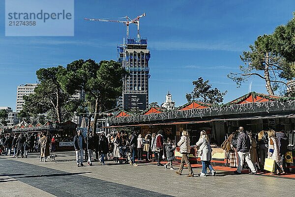 Madrid  Spanien  12. Dezember 2021: Menschen auf dem Kunst und Handwerksmarkt auf der Plaza de Colon im Zentrum Madrids. Menschen kaufen an Ständen ein  Europa