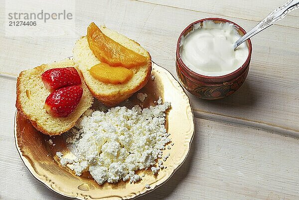 Sandwiches mit Hüttenkäse und saurer Sahne und Sandwiches mit Beeren und Früchten auf weißem Tisch