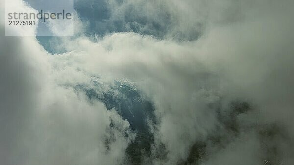 Fliegen durch schöne weiße flauschige Wolken zwischen hohen felsigen Bergen. Dolomiten Alpen Berge  Italien  Europa