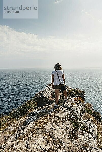 Schöne Frau auf den Klippen mit Blick auf das Meer in der Gegend von Cap Frehel  Bretagne  Frankreich. Atlantischer Ozean Französische Küste