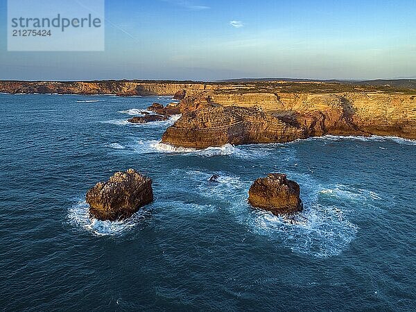 Luftaufnahme der Atlantikküste mit Felsklippen und Wellen bei Sonnenuntergang in Portugal