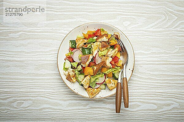 Traditionelle Levante Gericht Fattoush Salat  arabische Küche  mit Fladenbrot Croutons  Gemüse  Kräuter. Gesunder vegetarischer Salat aus dem Nahen Osten  rustikaler hölzerner weißer Hintergrund von oben  Lebensmittel Fotografie