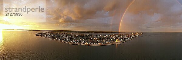 Regen fällt  während die Sonne mitten in der Nacht in Kotzebue Alaska scheint und einen schönen Kontrast zwischen Sonnenaufgang und Sturm schafft