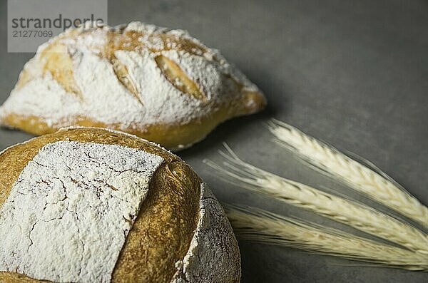 Schönes Sauerteigbrot auf grauem Hintergrund mit getrockneter Weizenblüte