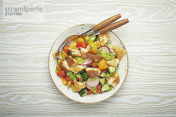 Traditionelle Levante Gericht Fattoush Salat  arabische Küche  mit Fladenbrot Croutons  Gemüse  Kräuter. Gesunder vegetarischer Salat aus dem Nahen Osten  rustikaler hölzerner weißer Hintergrund von oben  Lebensmittel Fotografie