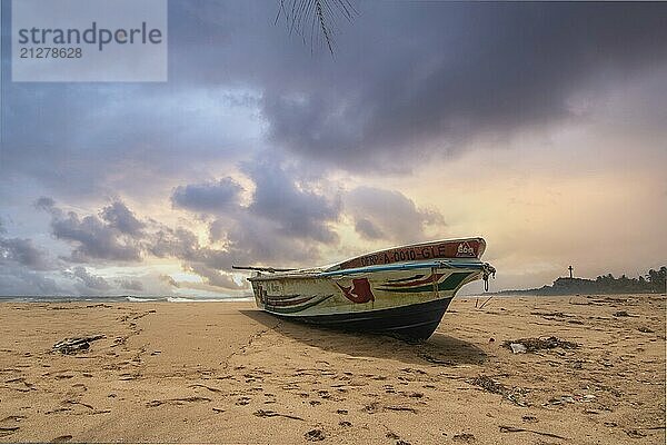 Strand  mit Boot und Blick auf das Meer am Abend bei Sonnenuntergang. Landschaft mit Wolken in Induruwa  Bentota Beach  Sri Lanka  Indien  Asien