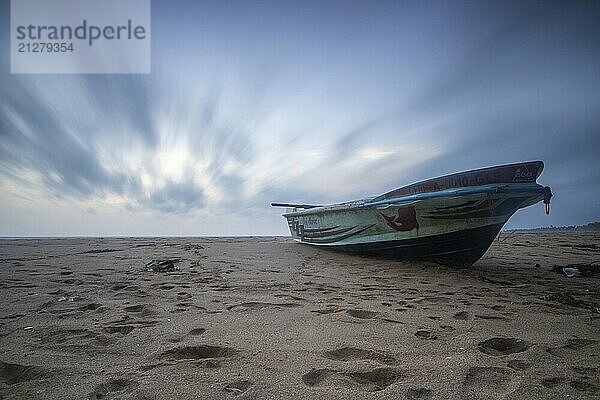 Strand  mit Boot und Blick auf das Meer am Abend bei Sonnenuntergang. Landschaft mit Wolken in Induruwa  Bentota Beach  Sri Lanka  Indien  Asien