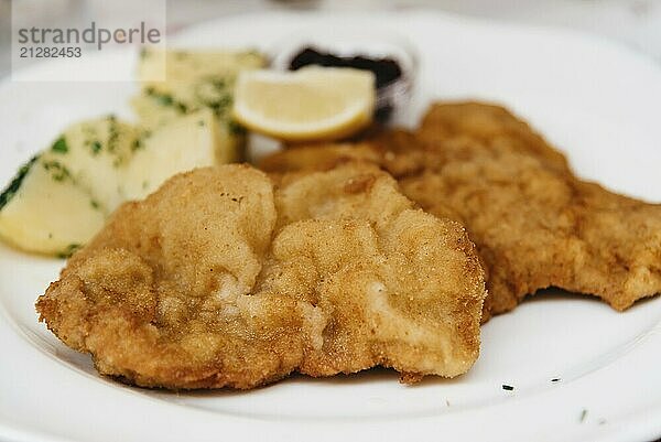 Nahaufnahme von Wiener Schnitzel auf weißem Teller im Restaurant  Seitenansicht