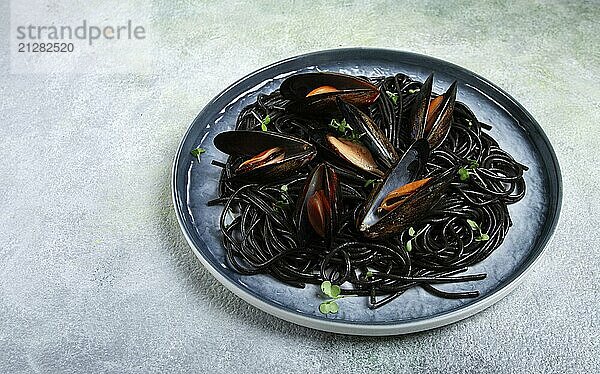 Foodfotografie  Schwarze Spaghetti  Neri Pasta  mit Muscheln  Draufsicht  auf grauem Hintergrund  hausgemacht  ohne Menschen