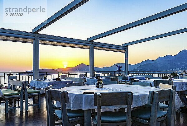 Romantisches Café auf der Terrasse mit Blick auf die Berge und den wunderschönen Sonnenuntergang über dem adriatischen Meer  Montenegro  Europa