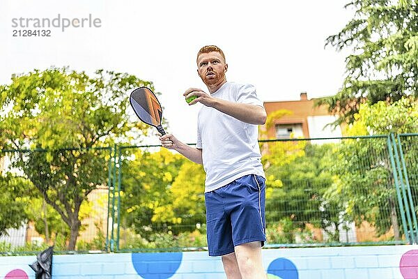 Mann vor dem Aufschlag beim Pickelballspielen auf einem Platz im Freien im Sommer